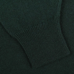 A close-up of the sleeve from the Tartan Green Deep V-Neck Lambswool Sweater by William Lockie reveals ribbed knitting at the cuff and a smooth texture on the main fabric, highlighting its exquisite craftsmanship.