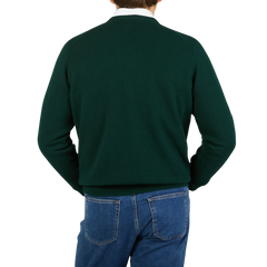 The back view of a man wearing a William Lockie Tartan Green Lambswool V-Neck Sweater and jeans.