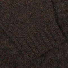 A close-up of a dark brown Turin Brushed Shetland Lambswool Crew Neck highlights its ribbed cuffs, echoing the classic style of a William Lockie sweater.