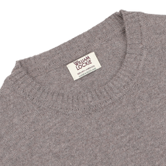 Close-up of the Vole Beige Crew Neck Lambswool Sweater with a label reading "William Lockie, Made in Scotland." The Scottish lambswool sweater features a ribbed neckline.