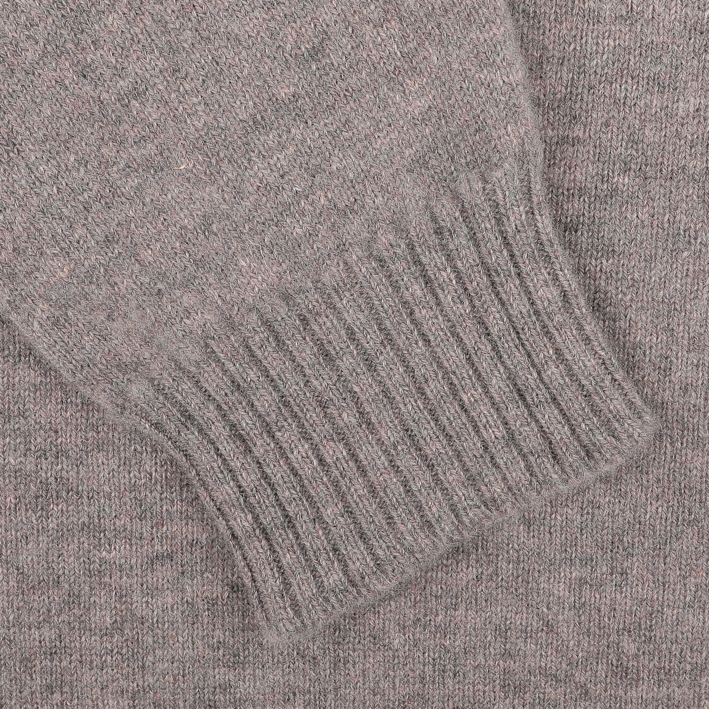 Close-up of a William Lockie Vole Beige Crew Neck Sweater sleeve, showcasing its ribbed-knit cuff, crafted from luxurious Scottish lambswool.