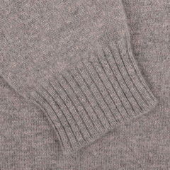 Close-up of a William Lockie Vole Beige Crew Neck Sweater sleeve, showcasing its ribbed-knit cuff, crafted from luxurious Scottish lambswool.