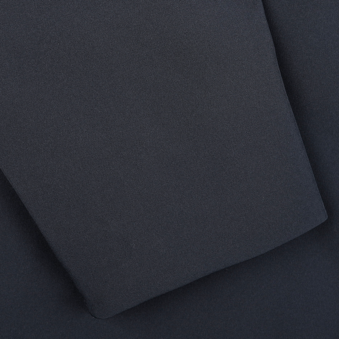 Close-up of the dark gray fabric from Woolrich's Melton Blue Pacific Soft Shell Jacket, featuring a folded corner that highlights its texture and weave.