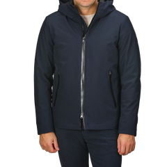 A person wearing a Melton Blue Pacific Soft Shell Jacket from Woolrich, featuring a front zipper and pockets, standing against a light gray background.