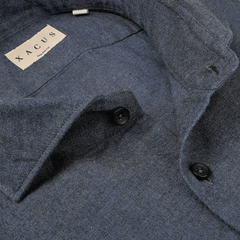 Close-up of a buttoned blue melange cotton flannel shirt collar featuring a label with the word "XACUS," highlighting the craftsmanship of this tailor fit shirt.