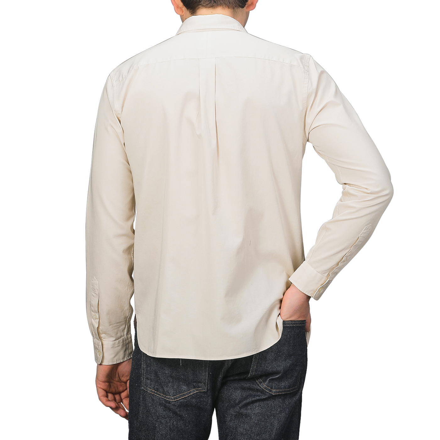 A person in a Cream Beige Cotton Twill Legacy Shirt by Xacus and dark jeans, seen from behind, casually slips one hand into their pocket.