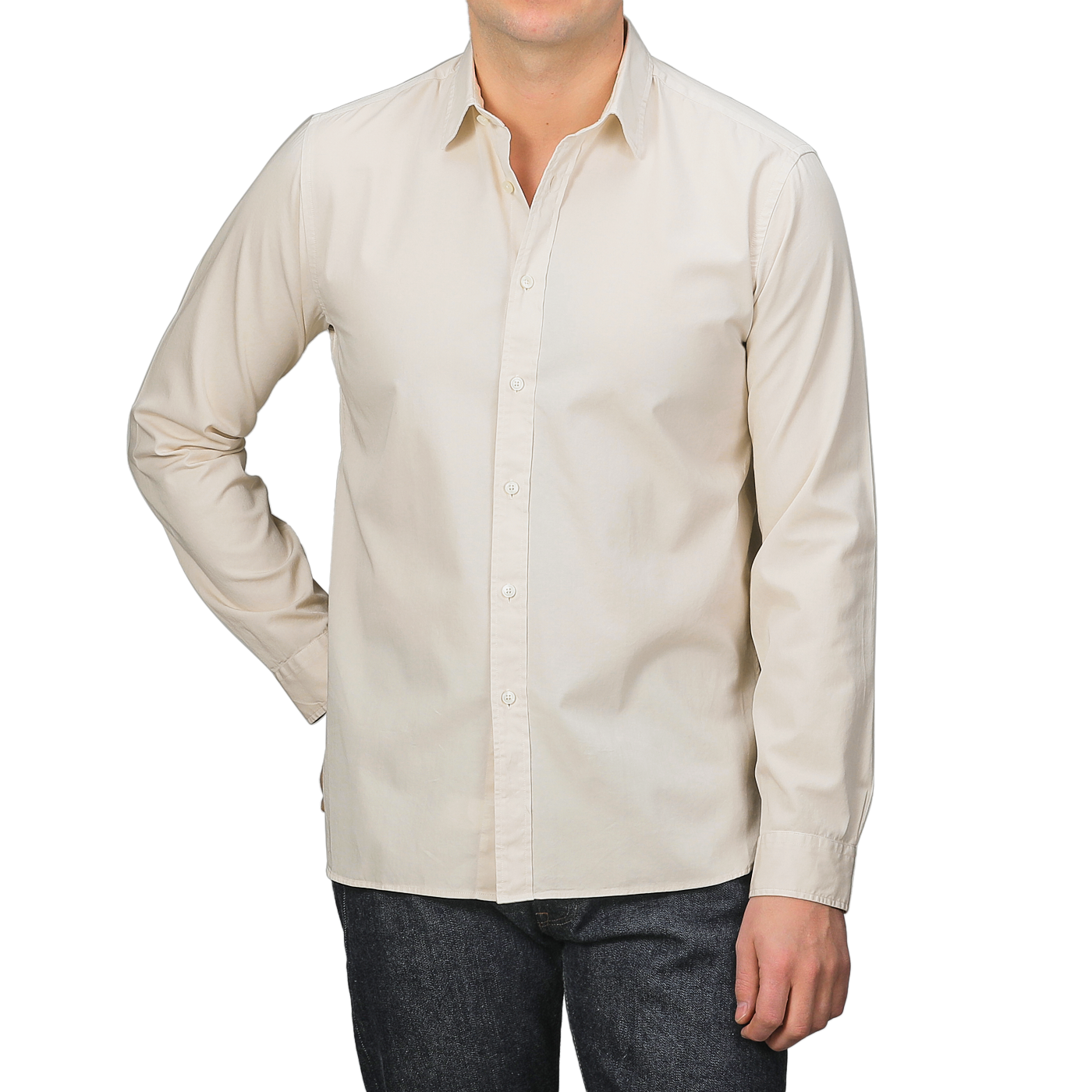 A man in an Xacus Cream Beige Cotton Twill Legacy Shirt and dark jeans stands against a neutral background, one hand in his pocket.