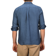 Someone wearing a Dark Blue Washed Linen Legacy Shirt by Xacus and beige pants, seen from behind.