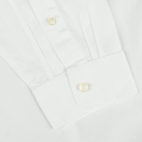 A close-up of the sleeve and cuff of the White Cotton Twill Legacy Shirt by Xacus, showcasing its white buttons and neatly stitched buttonhole.