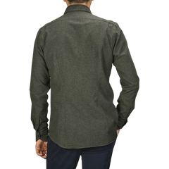 A person is seen from the back wearing an Xacus Green Melange Cotton Flannel Tailor Fit Shirt and dark pants, standing against a plain gray background.