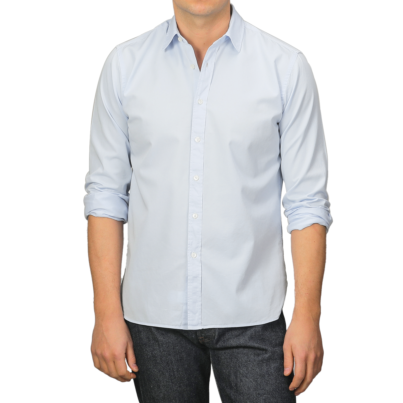 A person wearing an Xacus Light Blue Cotton Twill Legacy Shirt with rolled-up sleeves and dark jeans stands against a plain background.