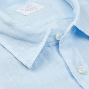 Close-up of a Xacus light blue washed linen legacy shirt collar with a visible tag and button.
