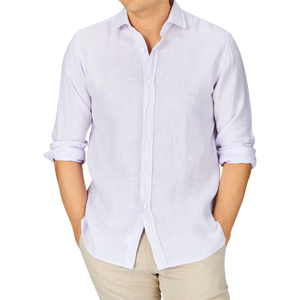 Man in a casual, unbuttoned Lilac Striped Washed Linen Legacy Shirt with rolled-up sleeves and beige trousers against a gray background by Xacus.