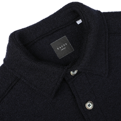 Close-up of the Navy Blue Boiled Wool Jersey Overshirt from Xacus, showcasing its collar, buttons, and an inner black label displaying the brand name "Xacus" and the word "Uno Uno.