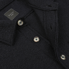 Close-up of a dark textured slim-fit coat made from boiled virgin wool, featuring three grey buttons and a visible brand label reading "Xacus 1956".