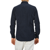 A person standing with their back to the camera, wearing a Navy Blue Cotton Corduroy Tailor Fit Shirt by Xacus and white pants.