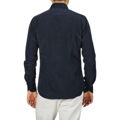 A person standing with their back to the camera, wearing a Navy Blue Cotton Corduroy Tailor Fit Shirt by Xacus and white pants.