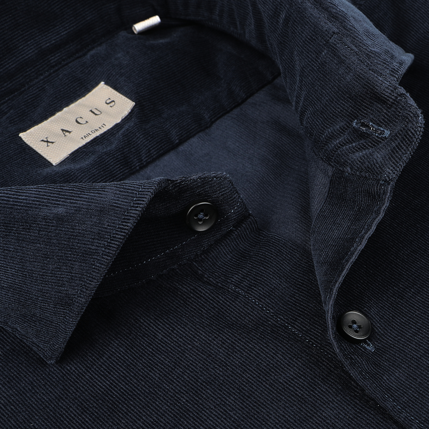 Close-up of the Navy Blue Cotton Corduroy Tailor Fit Shirt by Xacus, highlighting its pure cotton corduroy fabric and a partially buttoned collar with a visible "Xacus" label.