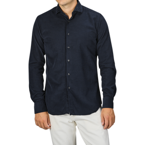 A person wearing a Navy Blue Cotton Corduroy Tailor Fit Shirt by Xacus and white pants against a gray background.