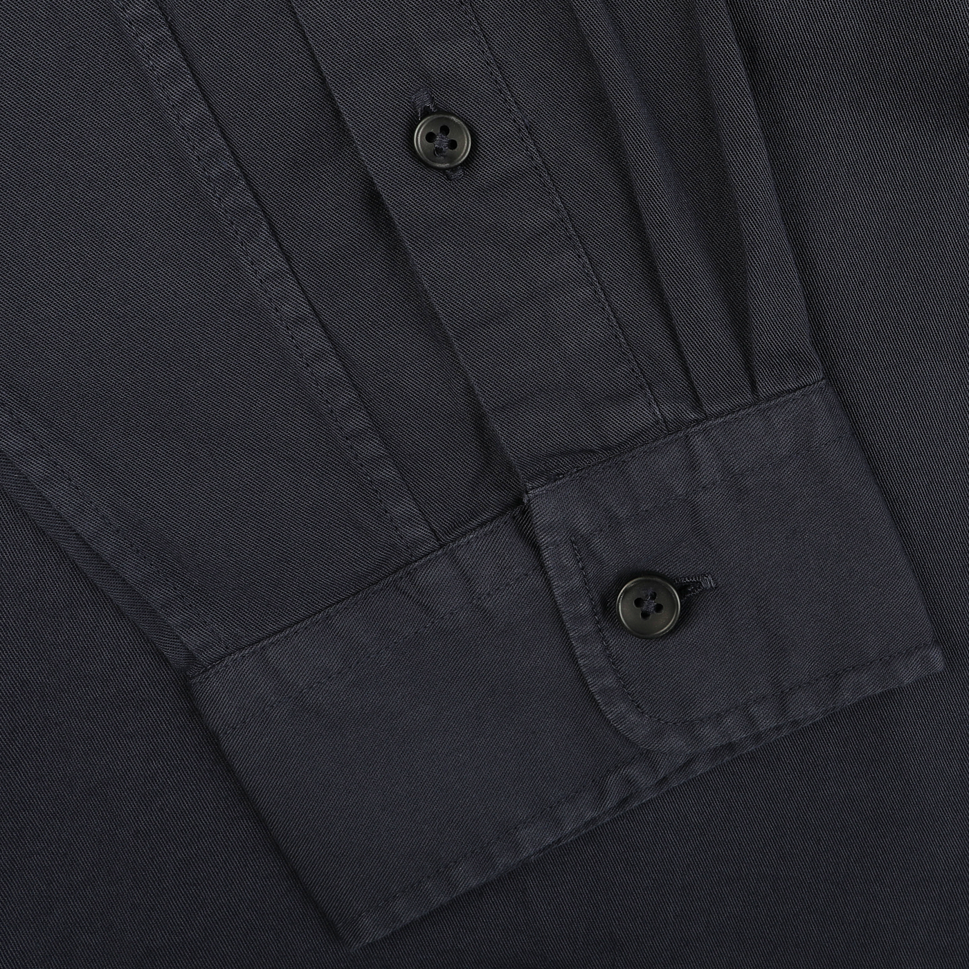 Close-up of a navy blue button-up casual shirt from Xacus, showcasing the cuff and sleeve with buttons, meticulously crafted from pure cotton twill for ultimate comfort.