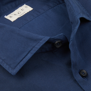 Close-up of a Xacus navy blue cotton twill tailor fit shirt collar with a branded label and buttons.