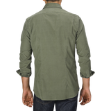 Person wearing an Xacus Olive Green Cotton Corduroy Tailor Fit Shirt and jeans, photographed from the back against a plain gray background.