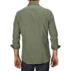 Person wearing an Xacus Olive Green Cotton Corduroy Tailor Fit Shirt and jeans, photographed from the back against a plain gray background.