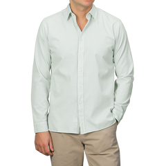 A person wears the Sage Green Cotton Twill Legacy Shirt by Xacus paired with beige pants, standing against a plain background.