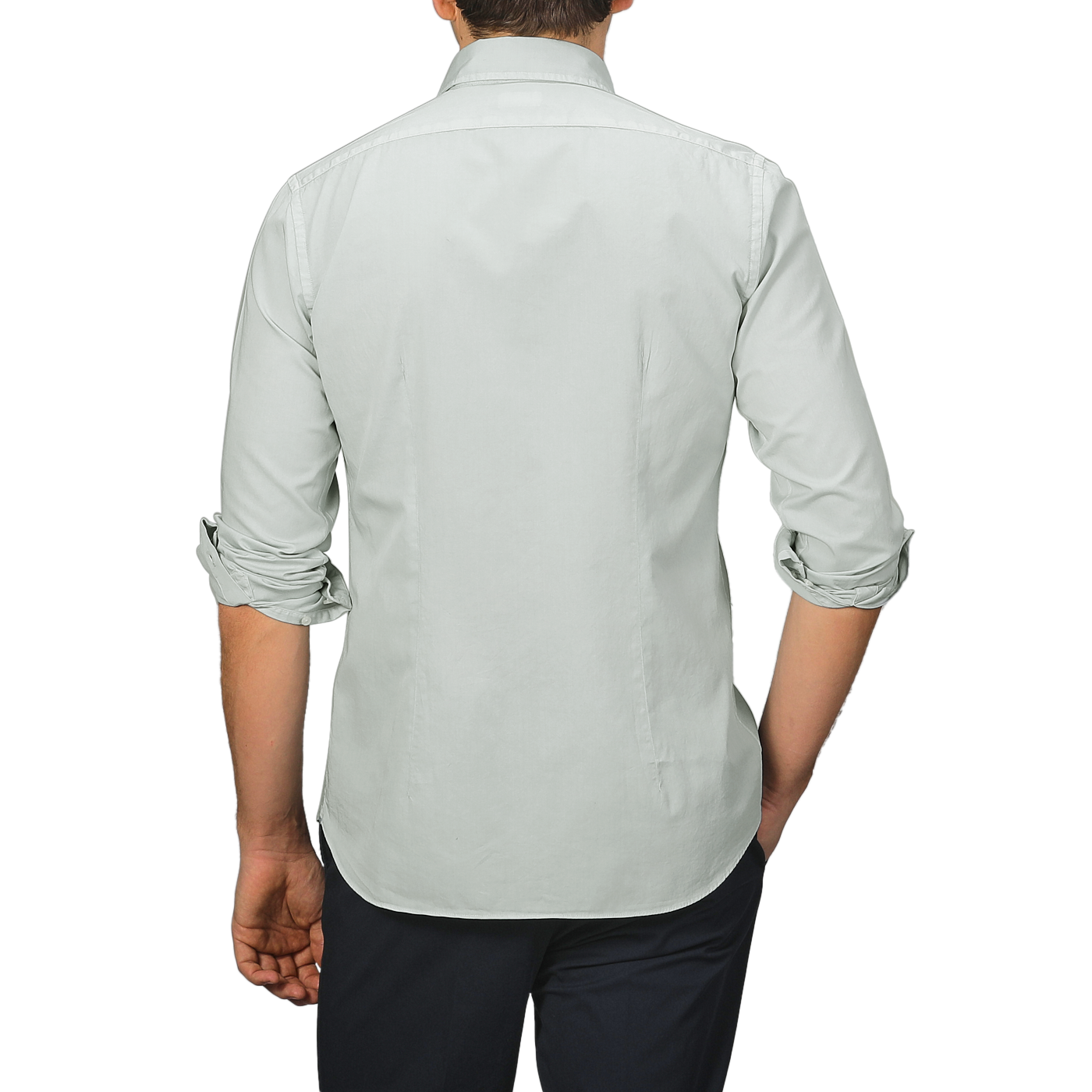 A person stands with their back to the camera, wearing a Sage Green Cotton Twill Tailor Fit Shirt by Xacus and dark pants.