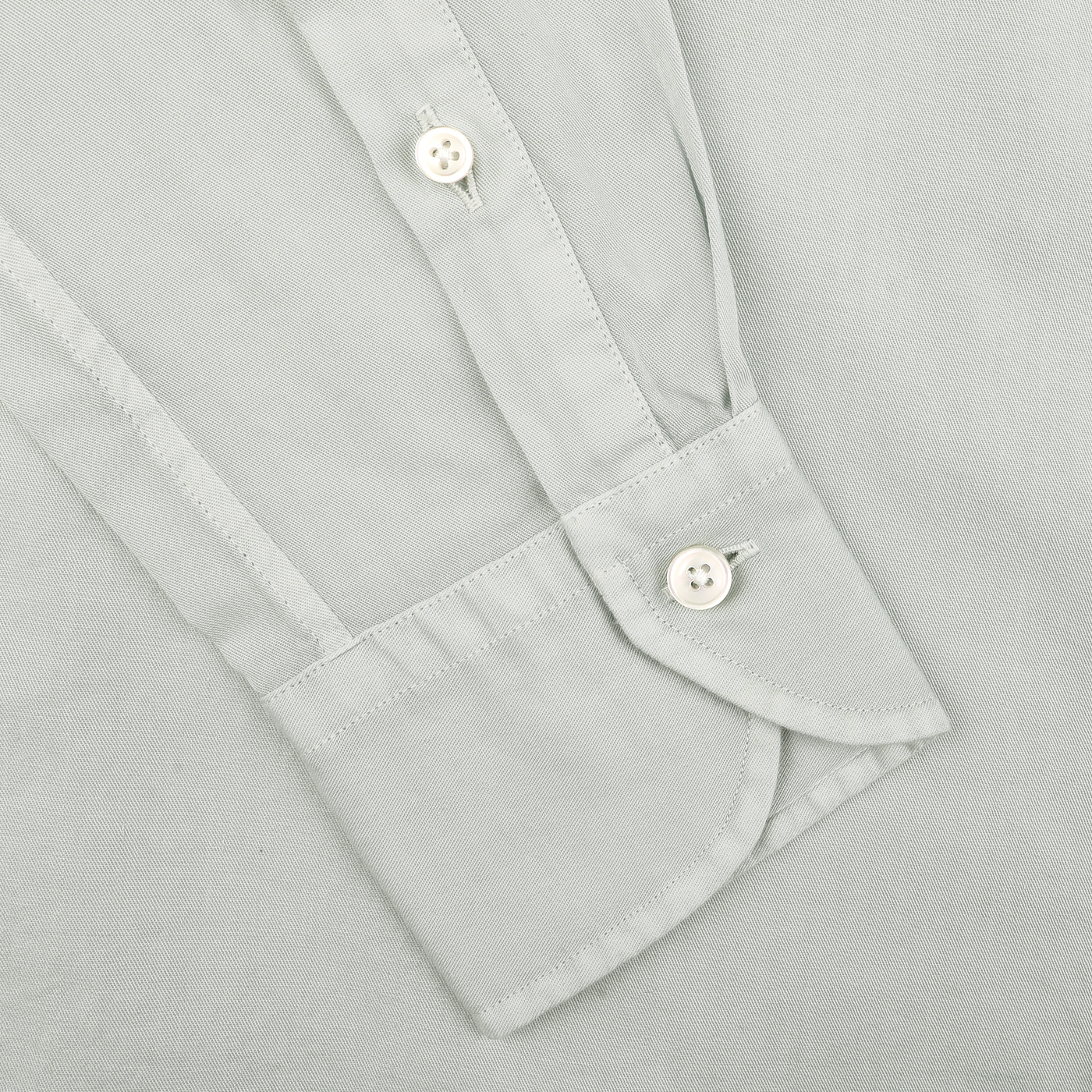 Close-up of the Sage Green Cotton Twill Tailor Fit Shirt sleeve by Xacus, featuring two white buttons and highlighting the button detail and fabric texture for a relaxed yet stylish appearance.