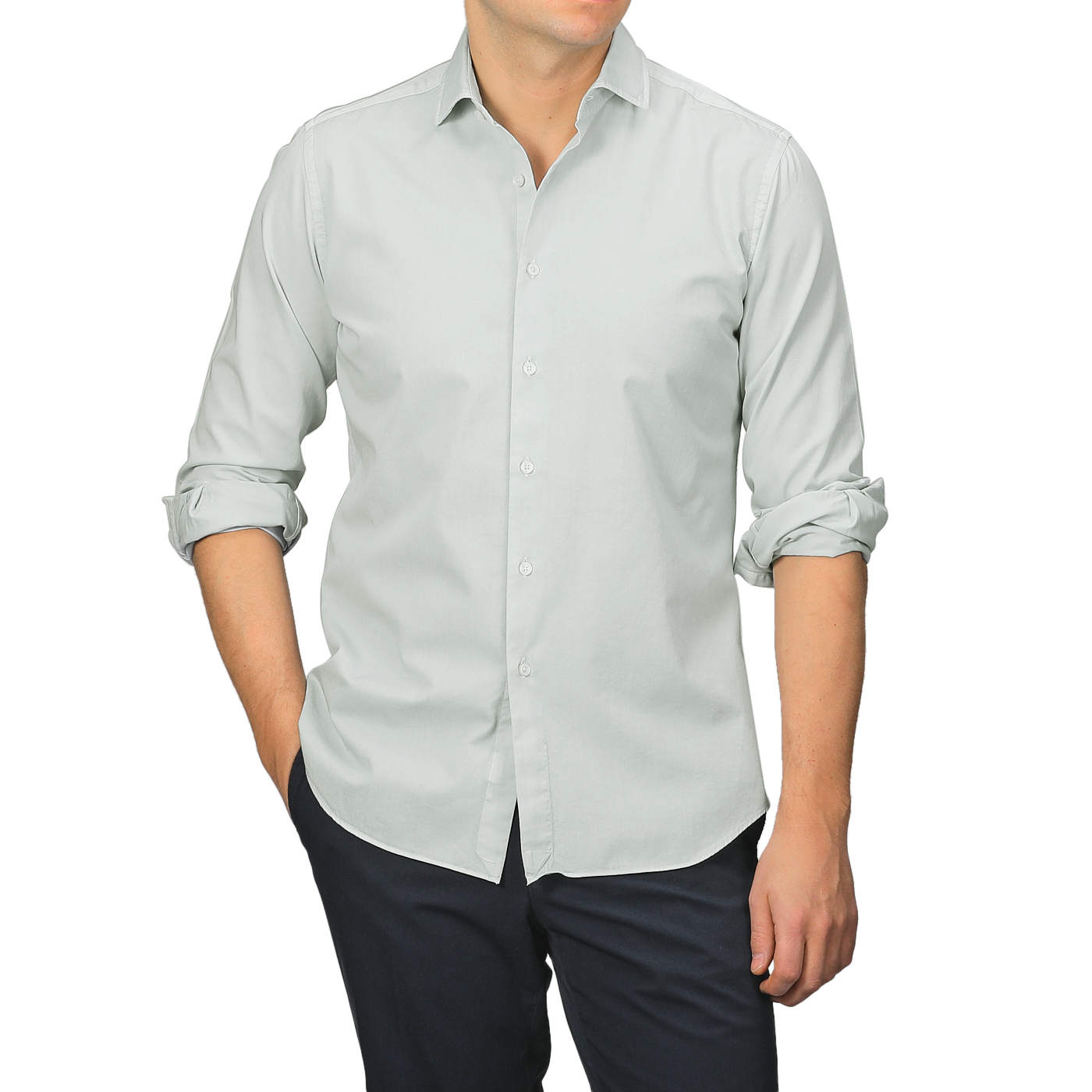 Dressed in a Sage Green Cotton Twill Tailor Fit Shirt with rolled sleeves by Xacus and dark trousers, a person stands against a neutral background.