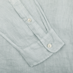 A close-up of the sleeve on the Sage Green Washed Linen Legacy Shirt by Xacus reveals two cuff buttons, highlighting its pure linen fabric's texture and intricate weave.