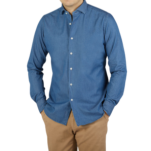 A man wearing a Xacus slim fit washed blue cotton denim casual shirt paired with tan pants.