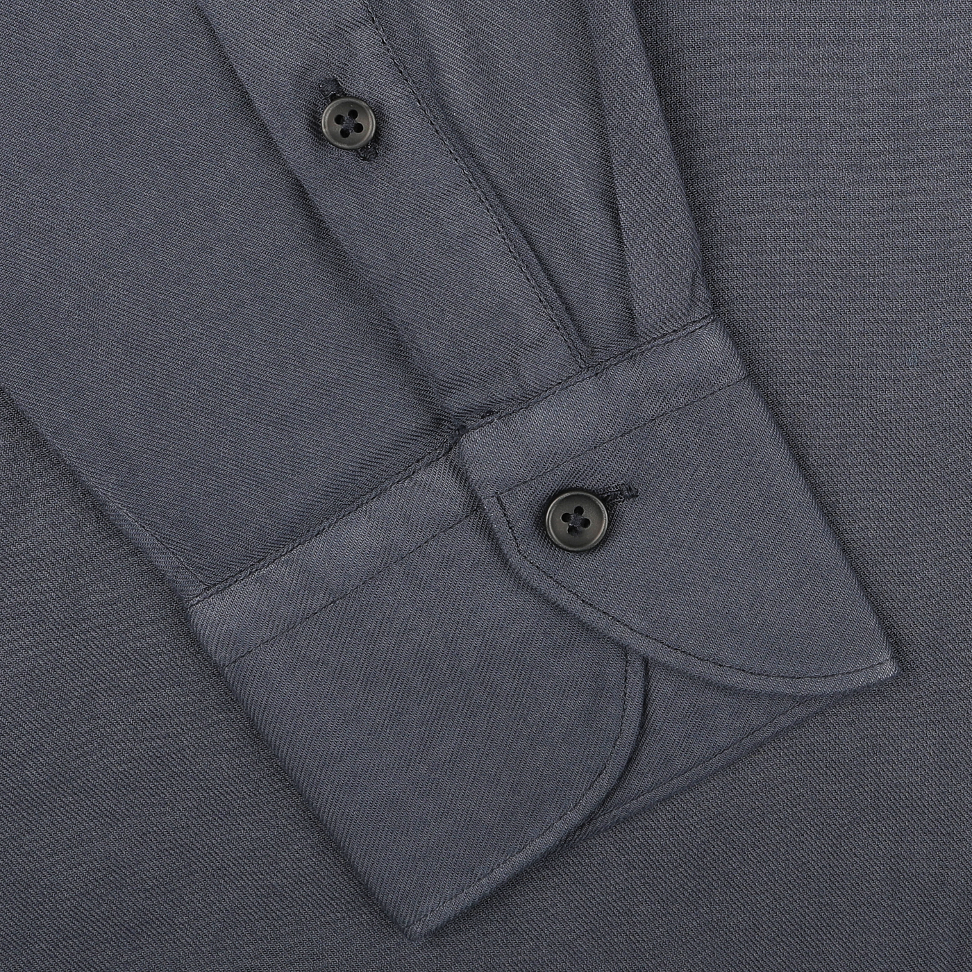 Close-up of a Washed Navy Mussola Cotton Tailor Fit Shirt cuff by Xacus, featuring two black buttons, neatly folded to highlight the pure mussola cotton fabric.