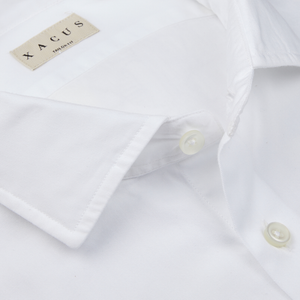 Close-up of a White Cotton Twill Tailor Fit Shirt with a label showing the Xacus brand.
