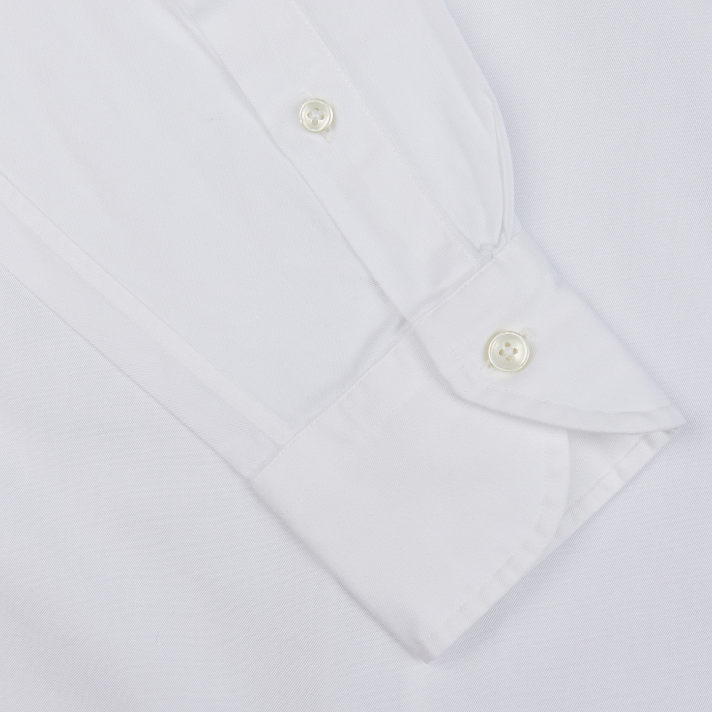 Close-up of a Xacus White Cotton Twill Tailor Fit Shirt cuff with buttons on a white background.