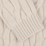 Close-up of the Ecru Beige Wool Cable Knit Rollneck by Zanone, showcasing its chunky cable-knit fabric made from virgin wool with detailed patterns and textures.