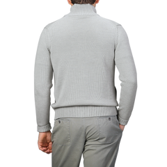 A person wearing a light gray Zanone merino wool button cardigan and gray pants, expertly crafted, viewed from the back.