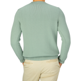 The back view of a man wearing a Zanone Aqua Green Cotton Crew Neck Sweater and khaki pants.