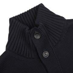 Close-up of a navy blue cardigan from Zanone, crafted from merino wool, showcasing a ribbed collar and two black buttons.