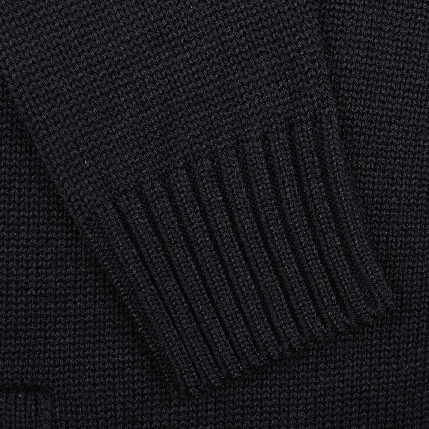 Close-up of a dark knitted fabric made from luxurious merino wool, highlighting a ribbed sleeve cuff from the classic Navy Blue Merino Wool Button Cardigan by Zanone.