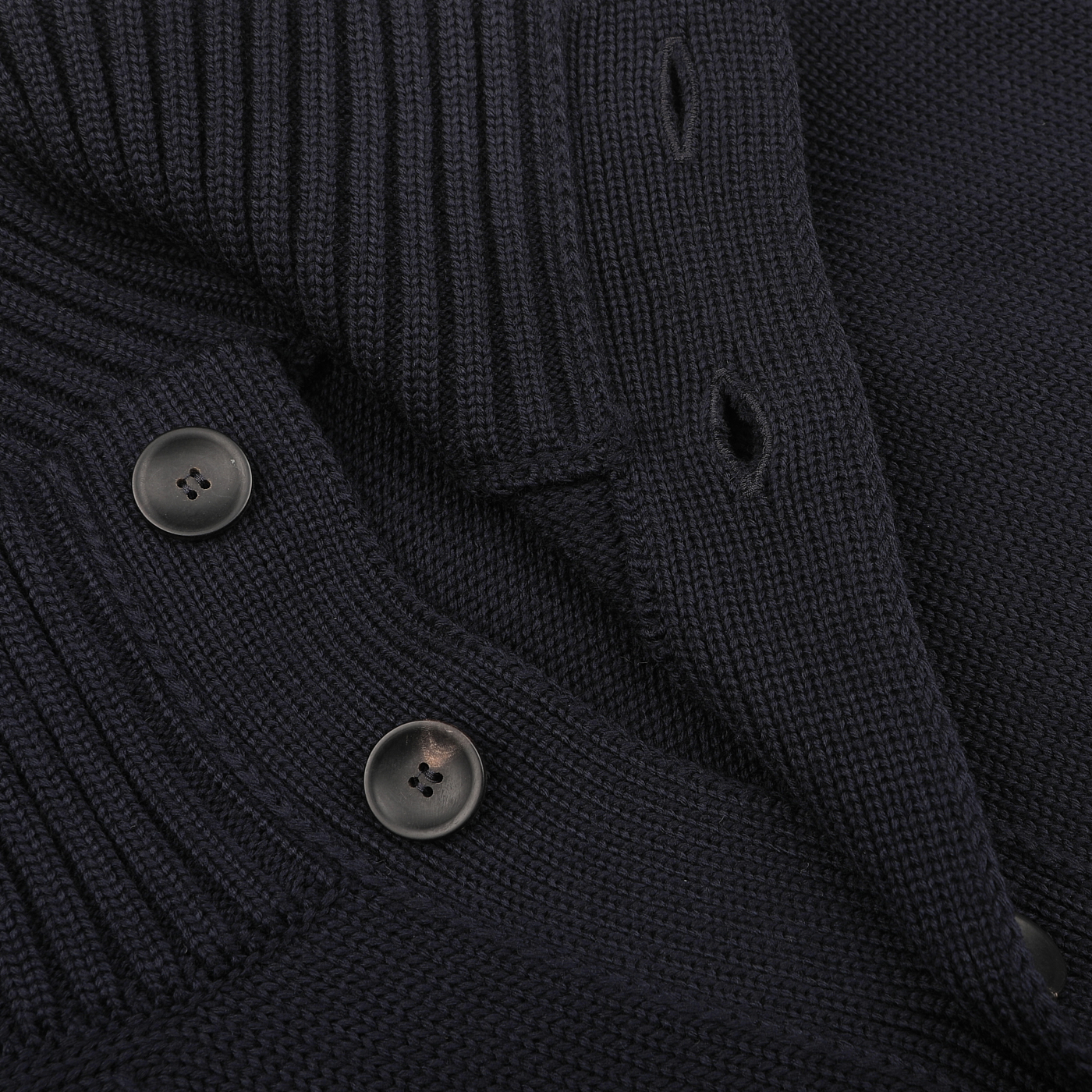 This close-up encapsulates the essence of the Navy Blue Merino Wool Button Cardigan by Zanone, highlighting its luxurious merino wool fabric, two visible black buttons, and ribbed texture along the collar and buttonholes.