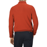 A person wearing a Zanone Rust Red Wool Quarter Zip Sweater and dark blue pants is shown from the back against a plain background.