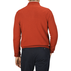 A person wearing a Zanone Rust Red Wool Quarter Zip Sweater and dark blue pants is shown from the back against a plain background.