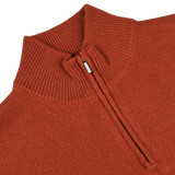 Close-up image of Zanone's Rust Red Wool Quarter Zip Sweater featuring a partially open zipper that reveals the ribbed texture of its virgin wool fabric.