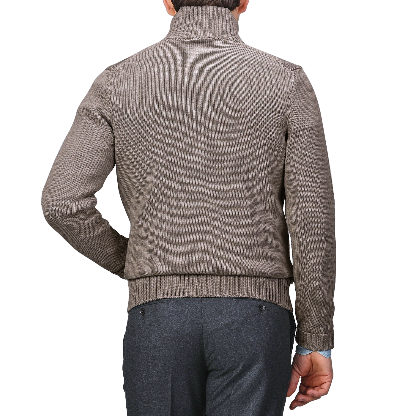 The individual, turned away from the camera, is dressed in a brown turtleneck sweater and gray pants, elegantly accessorized with a Taupe Beige Merino Wool Button Cardigan by Zanone.