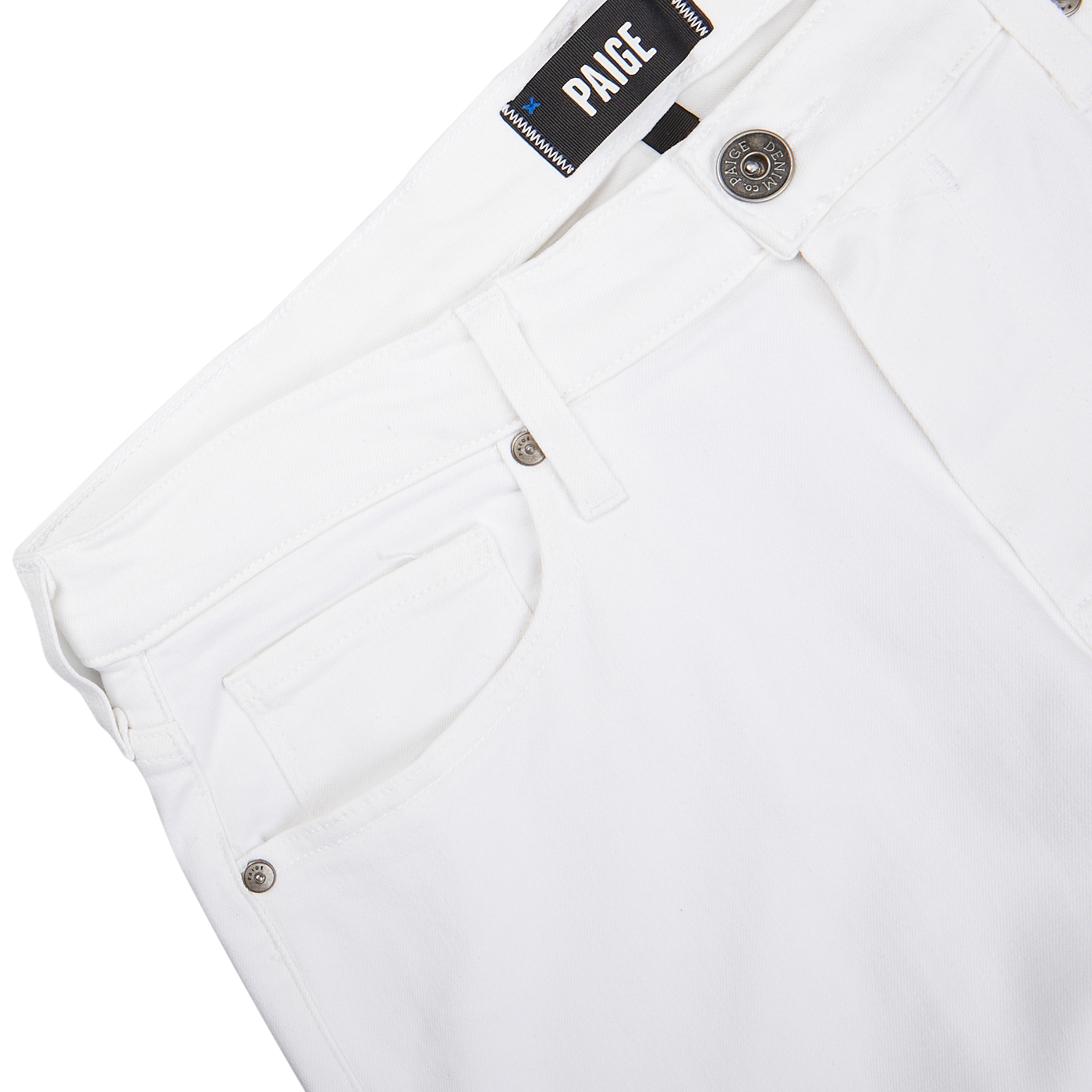 Close-up view of a white pair of Icecap White Cotton Transcend Federal Slim Jeans with a "Paige" brand label.