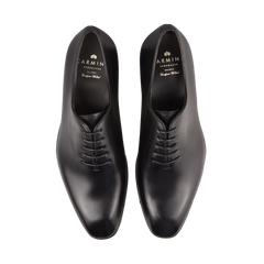 Pair of Black Calf Leather Wholecut Rain Oxford Shoes with laces, viewed from above. These sleek, polished shoes feature a Goodyear welted construction for exceptional durability. Branding inside the shoes shows "Carmina" and "Shoemaker.