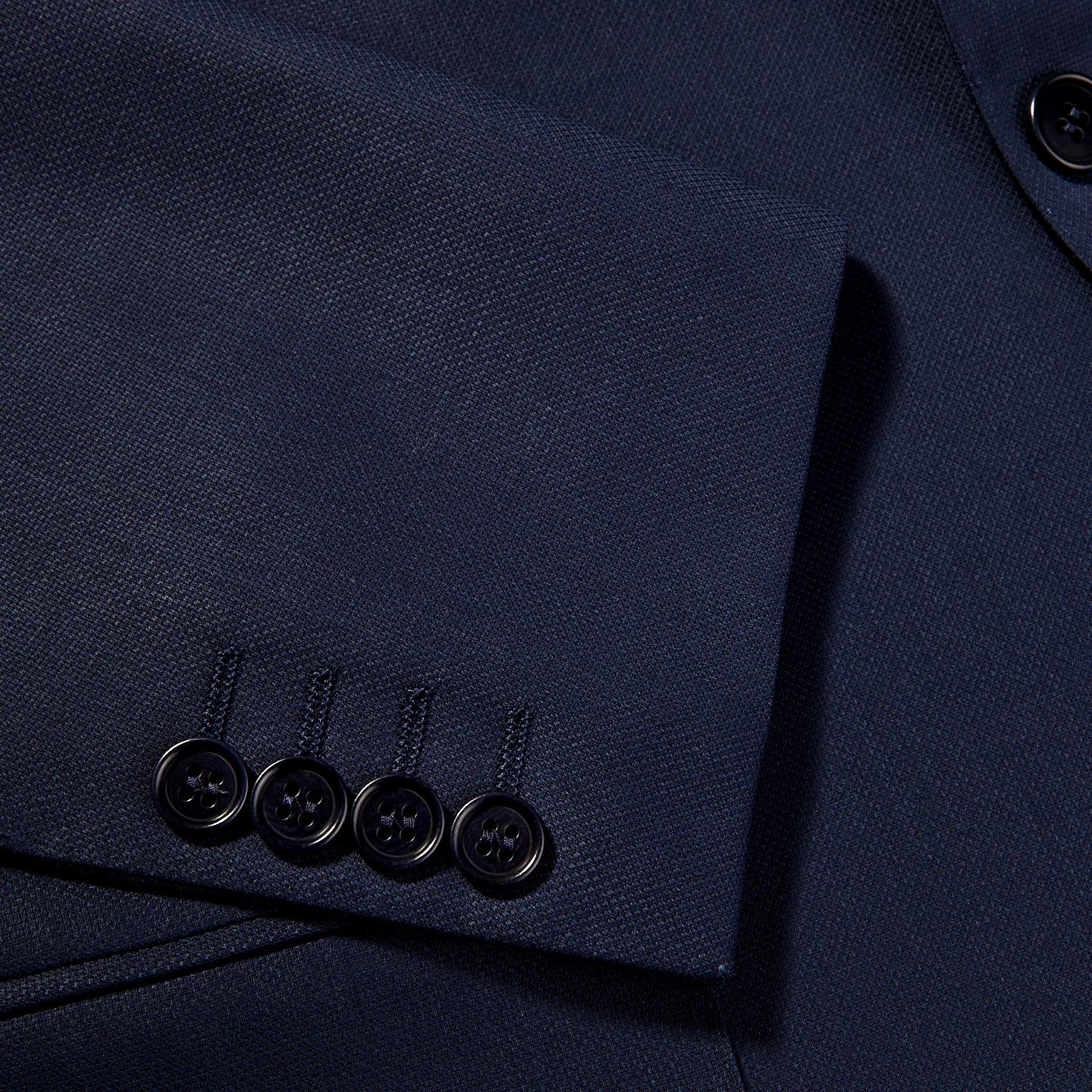 A close up of the wrinkle resistant buttons on a Canali Blue Wool Hopsack Travel Blazer.