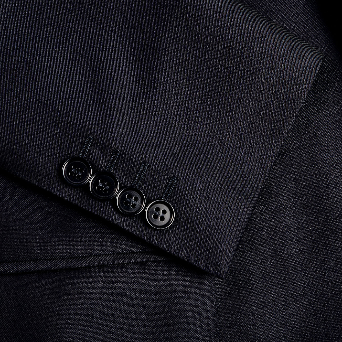 A close up of a button on a Canali Navy Blue Wool Notch Lapel Suit.